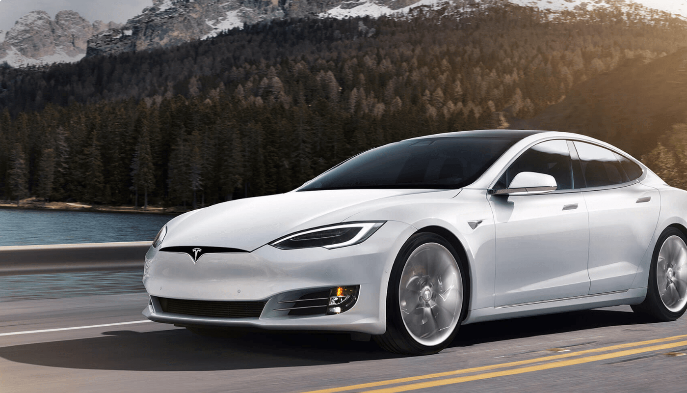 Tesla Model S driving with a forest and lake background